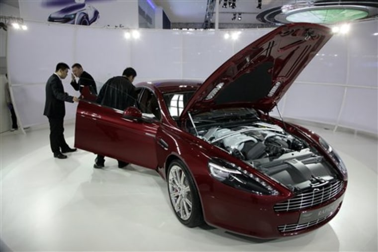 Guests look at the Aston Martin concept Rapide sports car at the Beijing Auto China 2010 show on April 25 in Beijing, China. China is a key growth market for sales of luxury automobiles.